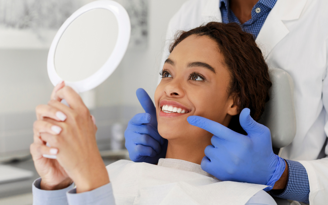 Dentist helping woman look at her smile in the mirror